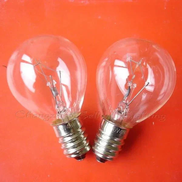 Two 220v 40w E14 miniature light bulbs with clear glass and silver bases on orange background