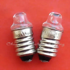 Close-up of two 1.1V 0.3A E10 miniature indicator bulbs on red background
