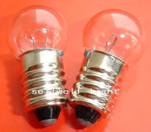 6W 6V E10 electric light source miniature bulbs with clear glass and metal bases on orange background