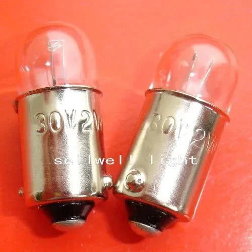 Two miniature light bulbs 30V 2W BA9S T10x24 with metal bases on red background