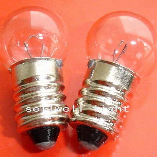 Close-up of two clear glass instruments bulb screw E10 lamp holders with metal screw bases on orange background