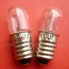 Two miniature 220v 2w E10 base clear glass light bulbs on a red background