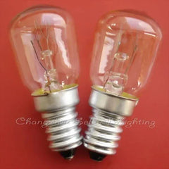 Two miniature 220v 15w E14S light bulbs with clear glass and silver screw bases on a red background