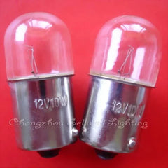 Two miniature 12v 10w BA15S base light bulbs with clear glass covers on red background